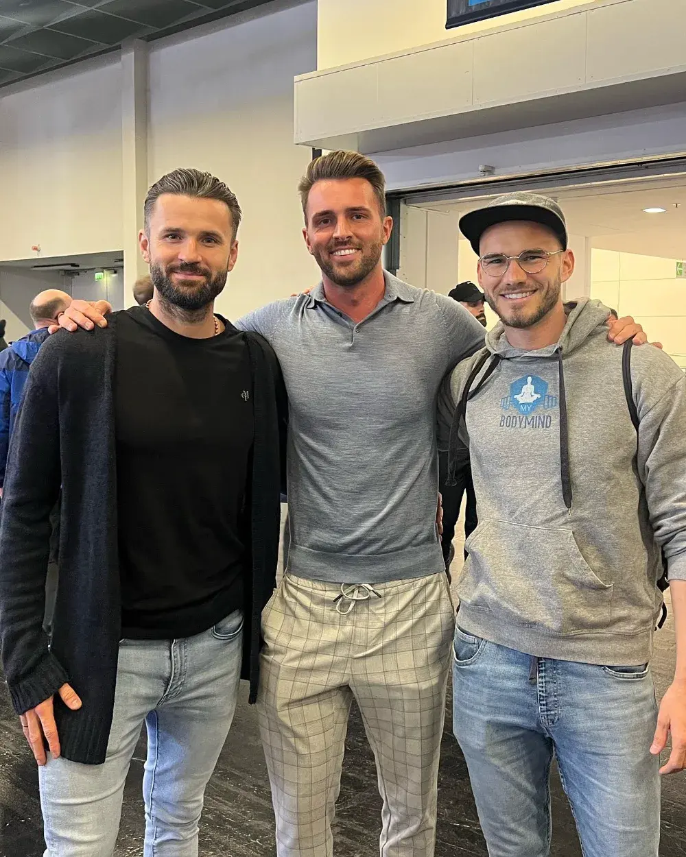 Kevin mit zwei Klienten auf einer Messe, einer davon im MYBODYMIND-Pullover