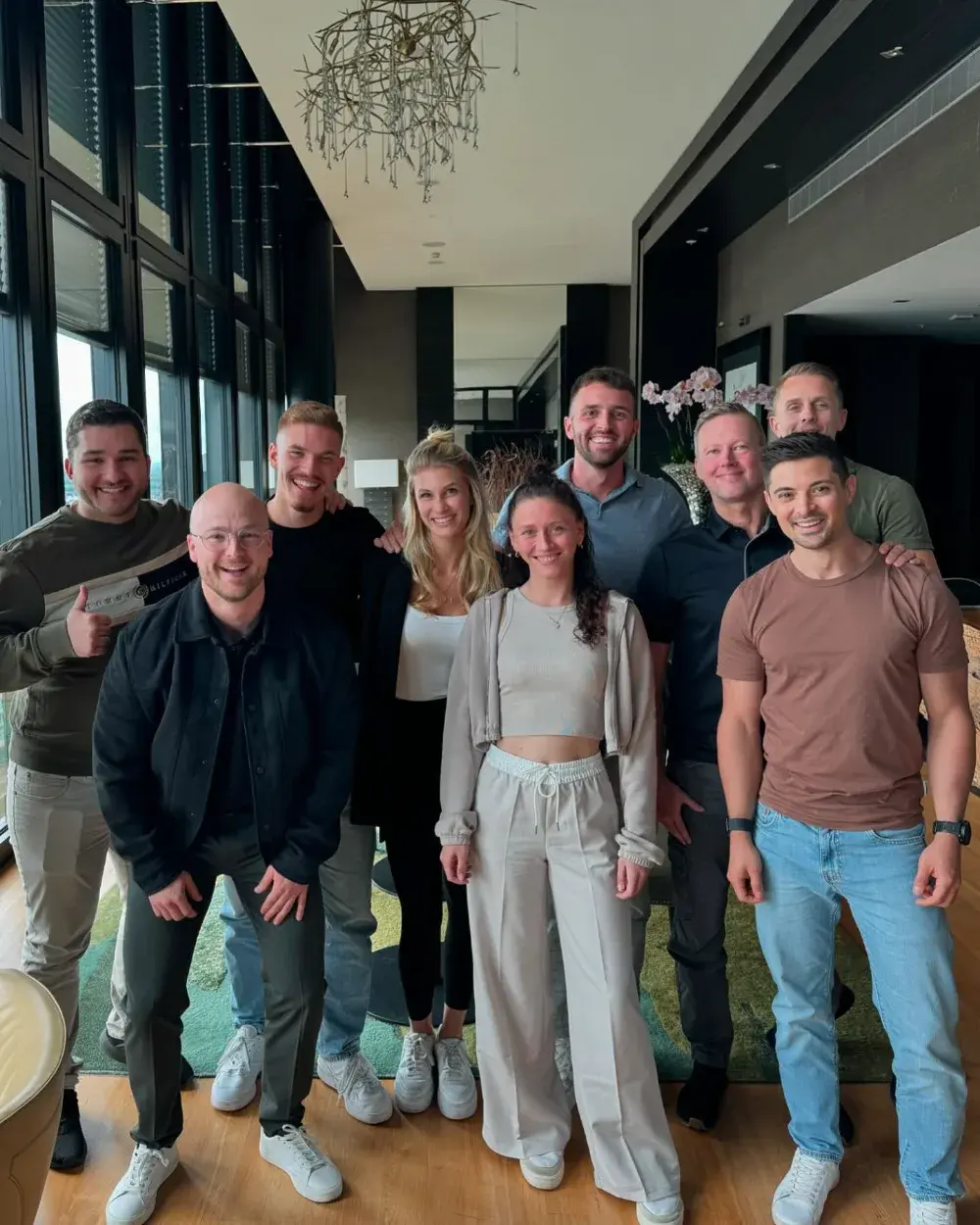 Gruppenfoto mit neun Klientinnen und Klienten in einem Penthouse